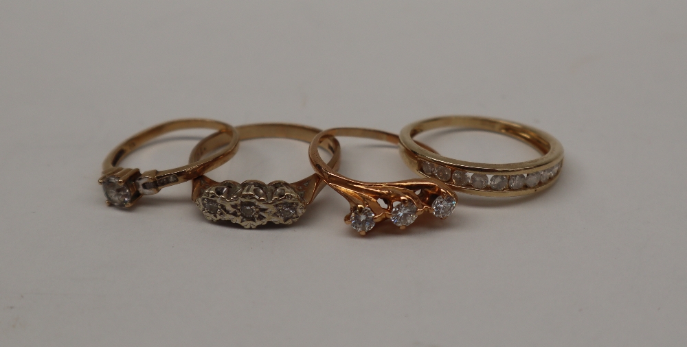 A 9ct gold three stone diamond ring, together with three other 9ct gold ring, approximately 8.