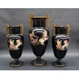 A garniture of three Grecian twin handled vases decorated with fighting gladiators to a black