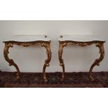 A pair of French marble and carved gilt wood pier tables, the white marble tops of serpentine form,