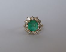 An emerald and diamond dress ring, set with an emerald cut emerald approximately 9mm x 8mm,