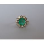 An emerald and diamond dress ring, set with an emerald cut emerald approximately 9mm x 8mm,