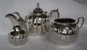 A Victorian silver three piece tea service, with lobed bodies and floral engraving,
