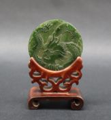 A Chinese carved jade disc depicting a dragon chasing a pearl, 6cm diameter,