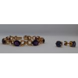 An 18ct gold bracelet, set with seven oval faceted amethysts,