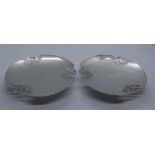 A pair of George VI silver pierced edge dishes of shaped circular form on a pedestal base,