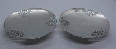 A pair of George VI silver pierced edge dishes of shaped circular form on a pedestal base,