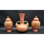 A trio of Derby porcelain vases with a pale pink ground and gilt highlights depicting flowers and