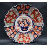 A large Japanese Imari charger decorated with radiating panels of flowers and geometric decoration,