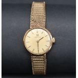 A lady's 9ct gold Omega wristwatch, the gilt dial with batons on an integral 9ct gold strap,