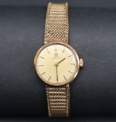 A lady's 9ct gold Omega wristwatch, the gilt dial with batons on an integral 9ct gold strap,