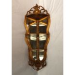 A gilt gesso corner wall unit with graduated shelves with a shell cresting and shield carved base,