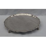 A George VI silver salver with beaded wavy edge on four ball and claw feet, 25cm diameter,