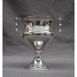 A George V silver twin handled trophy cup with turned handles and a baluster body on a spreading