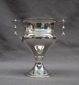A George V silver twin handled trophy cup with turned handles and a baluster body on a spreading