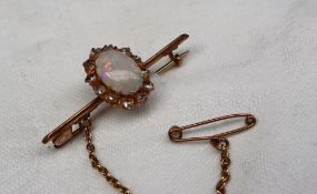 An opal and diamond bar brooch, set with an oval opal 11mm x 8mm,