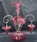A Victorian cranberry glass epergne, with a central trumpet and three other trumpets,