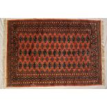 A Turkoman rug, with a pink ground and multiple guls,
