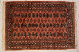 A Turkoman rug, with a pink ground and multiple guls,