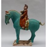 A Tang Dynasty style pottery statuette of a horse mounted with a bearded musician playing a string
