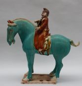 A Tang Dynasty style pottery statuette of a horse mounted with a bearded musician playing a string