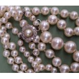 A pearl necklace with graduated beads, with a diamond set clasop together with a locket,