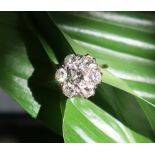 A diamond cluster ring, set with a central round brilliant cut diamond approximately 0.