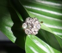 A diamond cluster ring, set with a central round brilliant cut diamond approximately 0.
