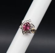 A ruby and diamond cluster ring, the central oval faceted ruby,