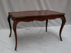 A French mahogany and gilt metal mounted coffee table with a serpentine top on cabriole legs and