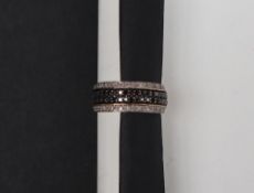 A diamond half eternity ring set with two central rows of black diamonds,