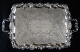 An Edward VII silver twin handled tray, with a d shaped edge cast with scrolls and leaves,