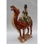 A Tang Dynasty style pottery statuette of a braying camel mounted with a female court musician