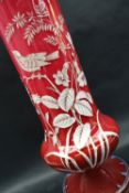 A Victorian opaque glass overlay decorated vase of tapering form on a spreading foot,