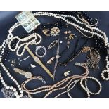 Assorted costume jewellery including brooches, beaded necklaces, faux pearls,