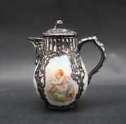 A Berlin porcelain and white metal overlaid milk jug and cover, with four painted panels,