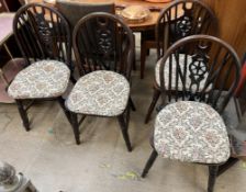 A set of four wheel and stick back dining chairs on turned legs