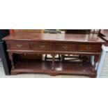 A 20th century mahogany dresser base with a rectangular planked top above four drawers on ring