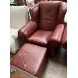 A brown leather upholstered wing back elbow chair with matching footstool