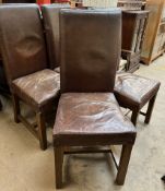 A set of four brown leather upholstered dining chairs on square oak legs