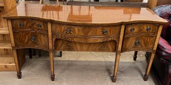 A Regency style mahogany sideboard with a serpentine top with two central drawers and two cupboards