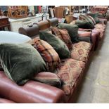 A pair of brown leather and material covered settees with a matching footstool