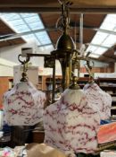 A brass ceiling light with a set of three shaped glass shades