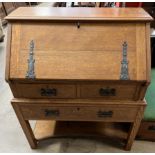 A 20th century oak bureau, the sloping fall enclosing a fitted interior, above two short,