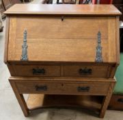 A 20th century oak bureau, the sloping fall enclosing a fitted interior, above two short,