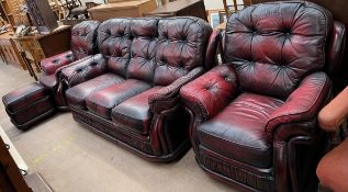 A red leather four piece suite comprising a three seater settee,