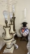 A pottery oil lamp decorated in reds and blues together with a brass corinthian column table lamp