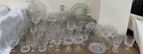 A cut glass jug together with a collection of cut glass drinking glasses,