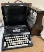 An oak cased tantalus together with a Silver Reed typewriter and a briefcase