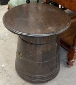 An oak table with a circular top and tapering body together with a wall mounted display cabinet