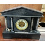 A black slate mantle clock of architectural form,